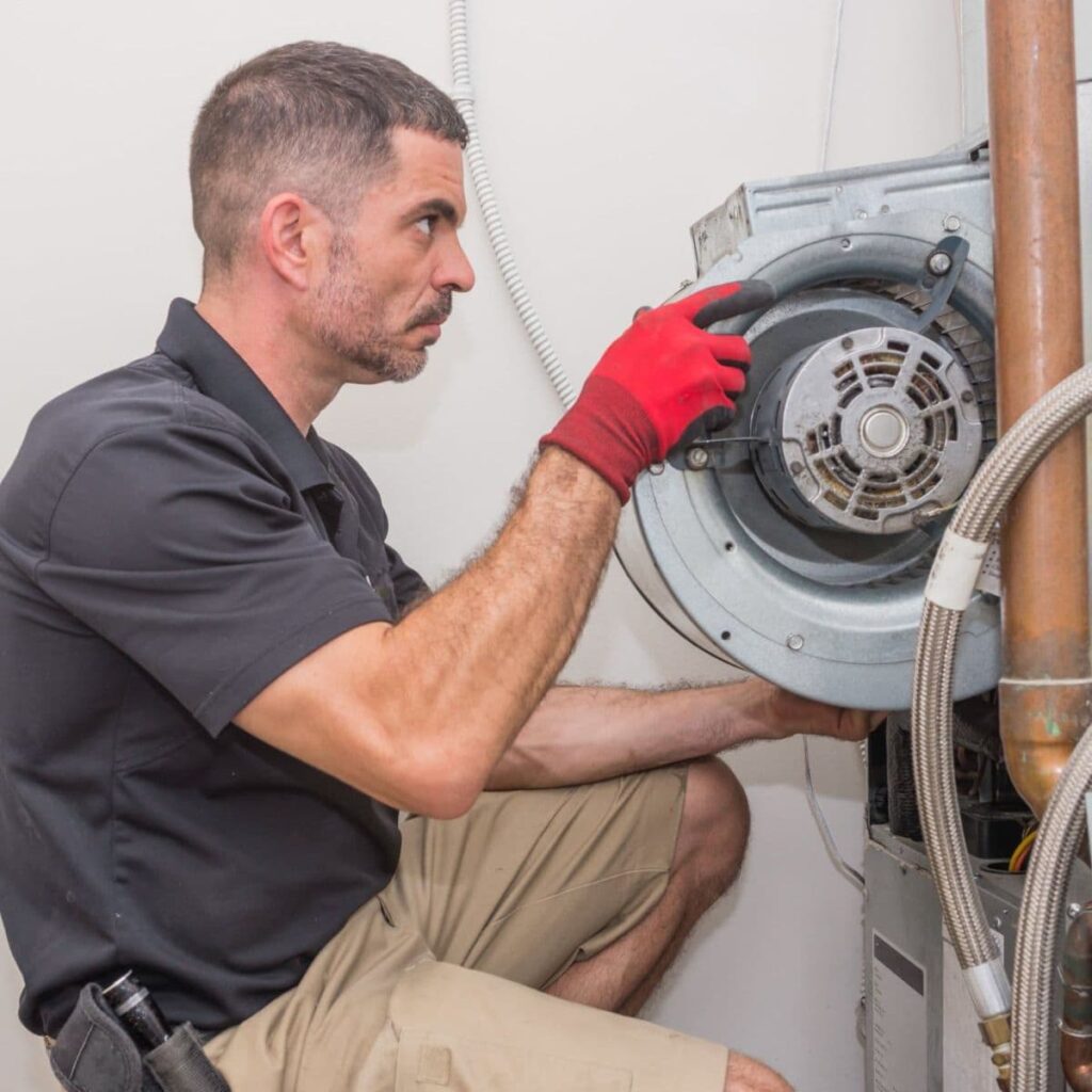 a service technician with gloved hands installing a part of a heater