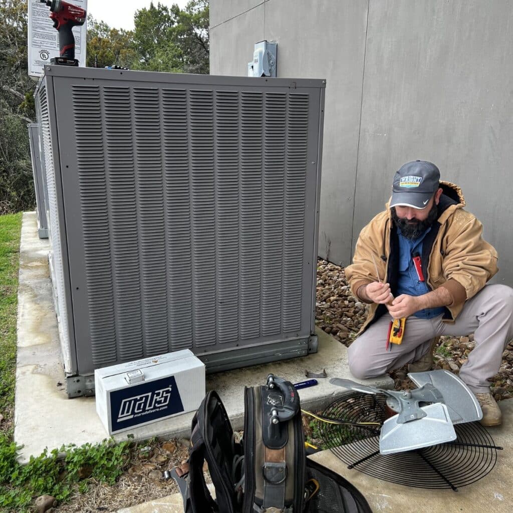 wright ac service technician making repairs on a large commercial outdoor ac unit