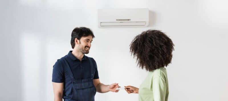 an ac technician giving a business card to a homeowner