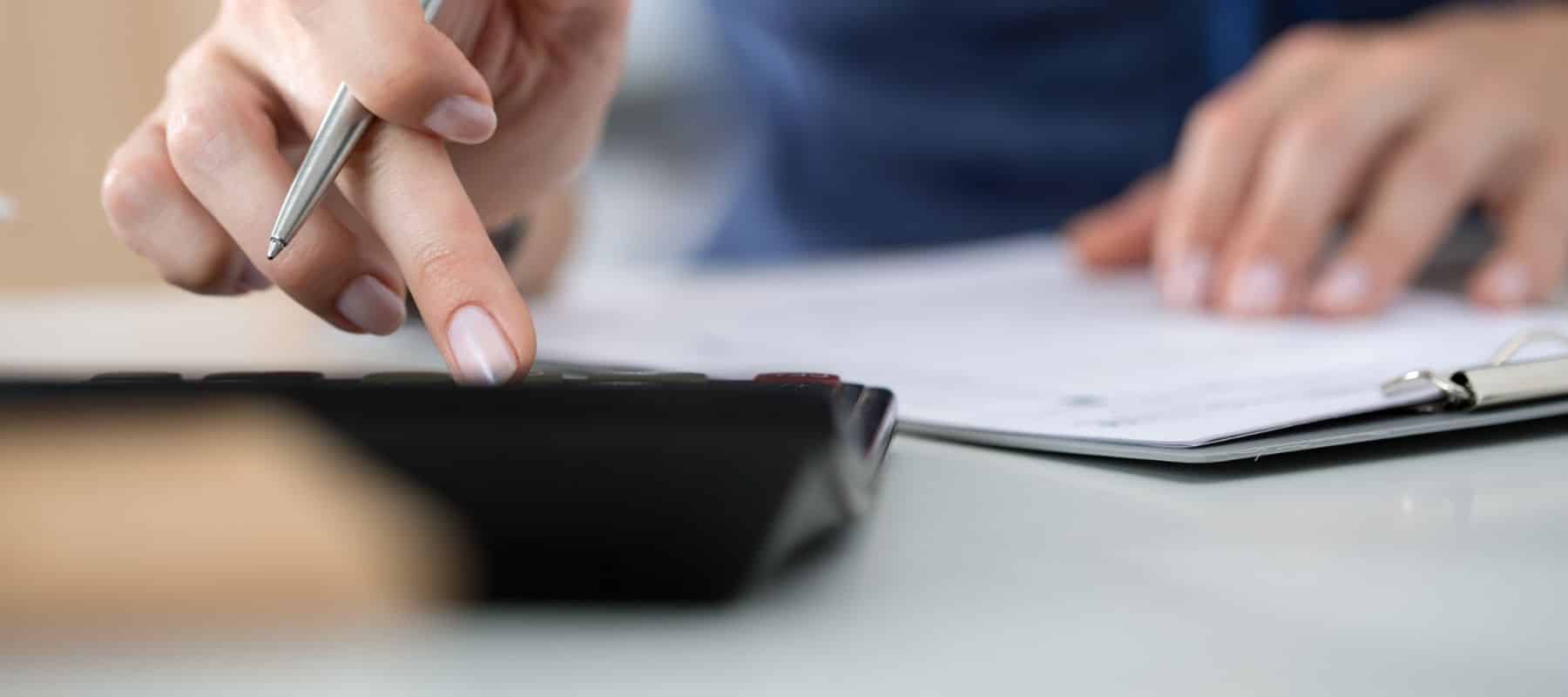 a woman typing into a calculator during financing