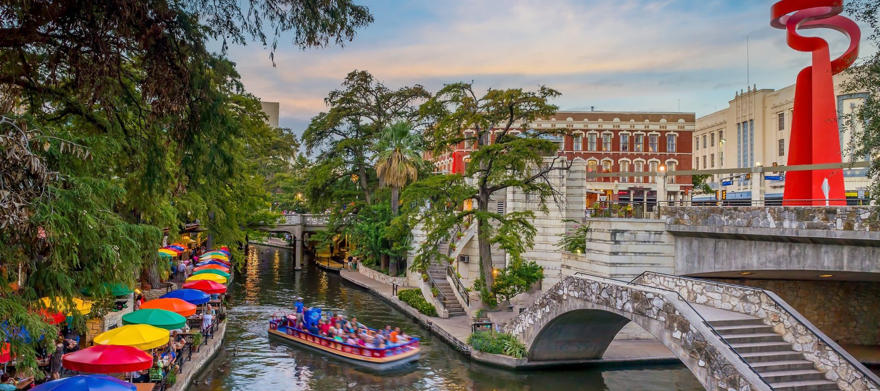 a boat going under a bridge at the San Antonio River Walk