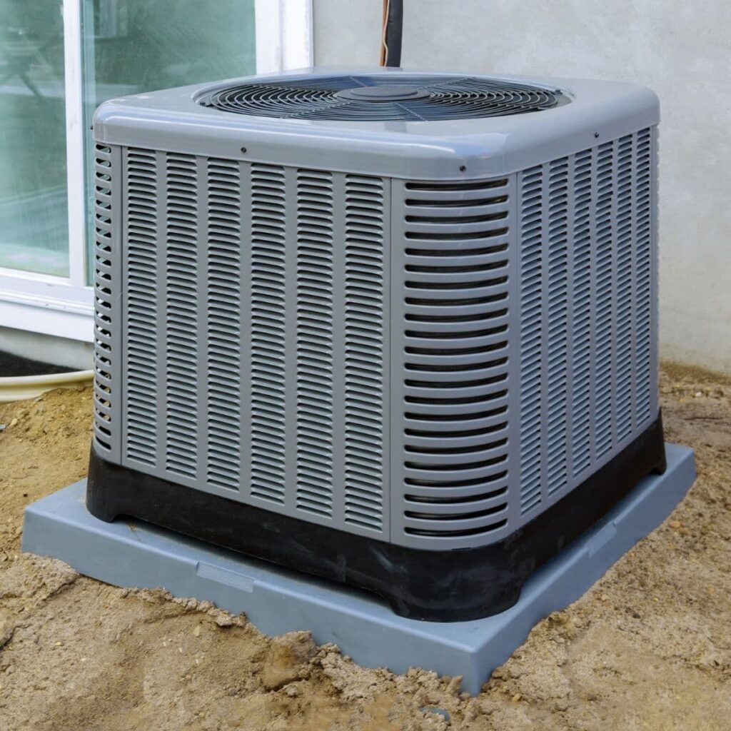 a gray outdoor ac unit installed on the side of a gray home