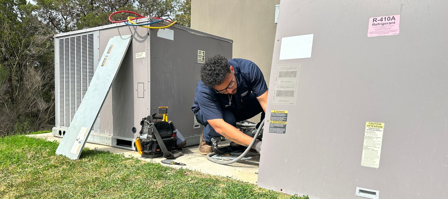 wright ac technician performing repairs on an outdoor hvac commercial unit