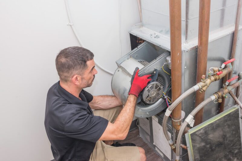 technician installing a part of a furnace to heat a home in san antonio