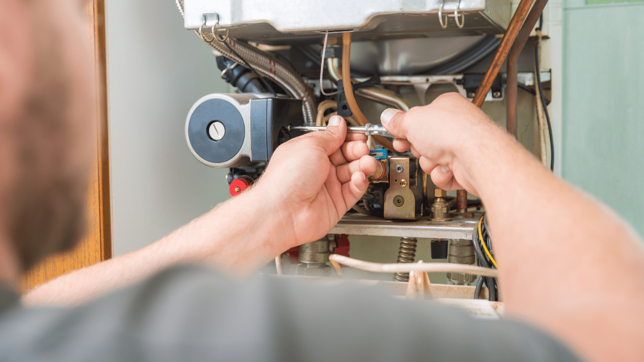 An HVAC technician repairing a gas furnace.
