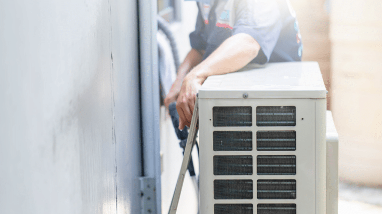 An HVAC technician working on an exterior heating unit.