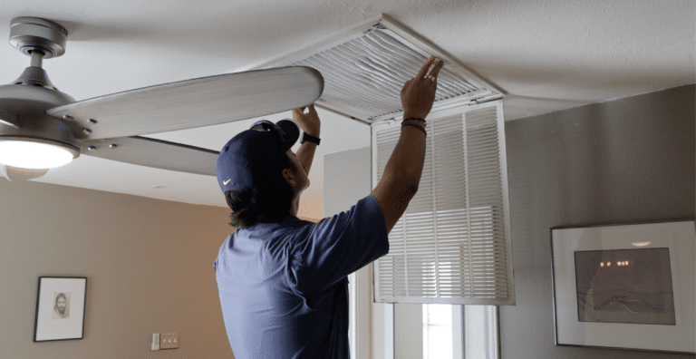 A Wright Services technician changing an air filter for an HVAC unit.