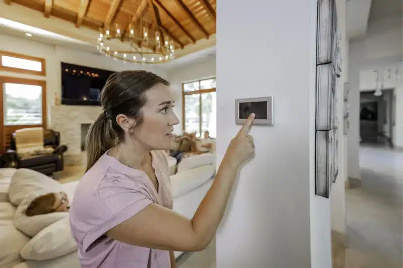 Person adjusting smart home thermostat.