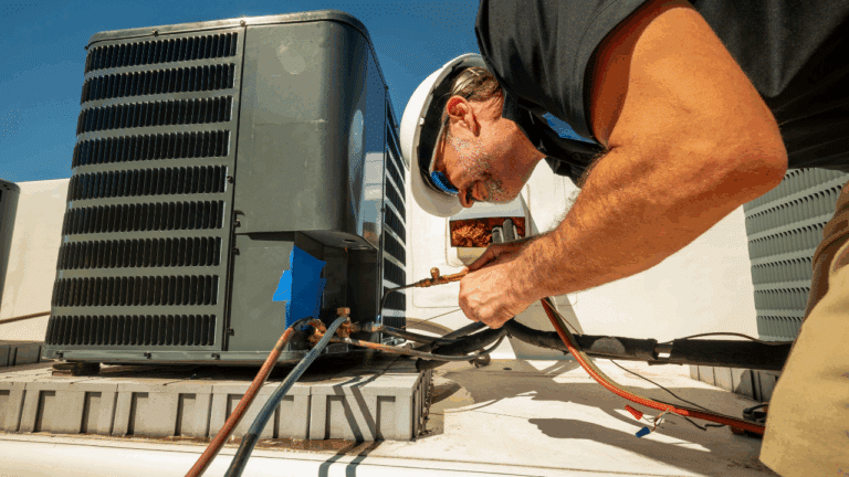 A man working on a commercial HVAC unit.