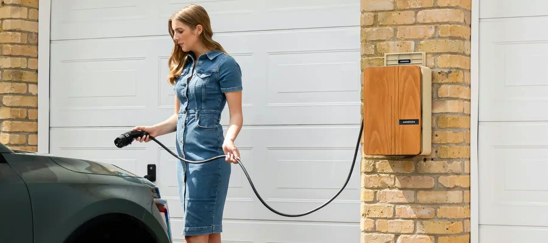 Woman charging electric vehicle at home.