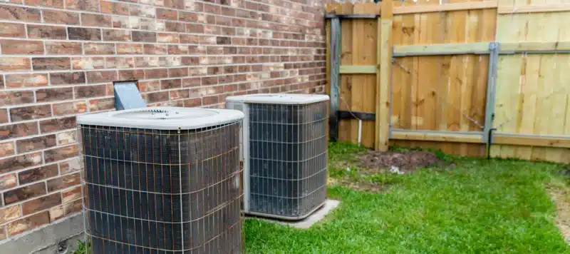 old hvac units placed outside of a brick house