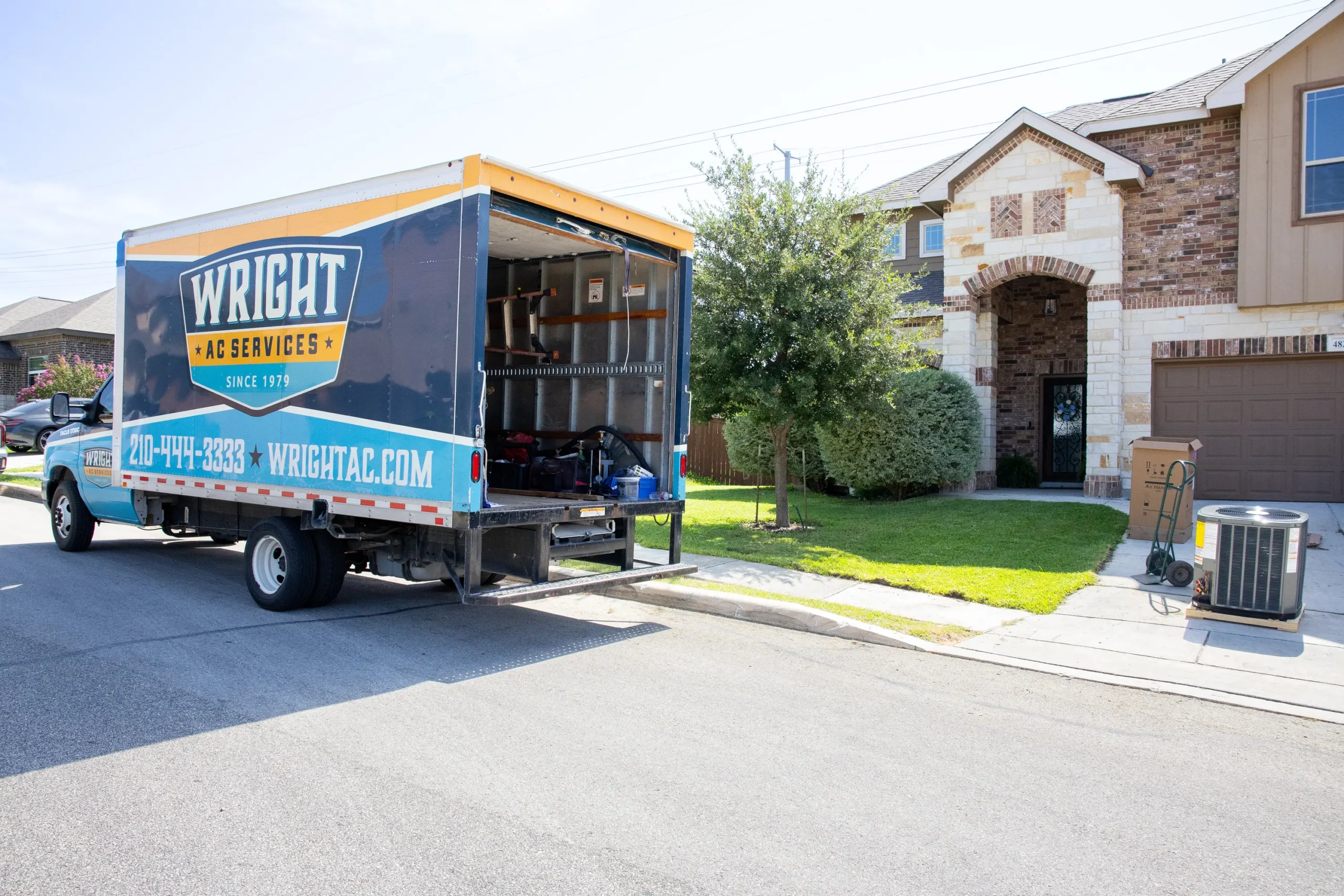 A Wright Home Services truck sitting in front of a home with old AC equipment in the driveway.