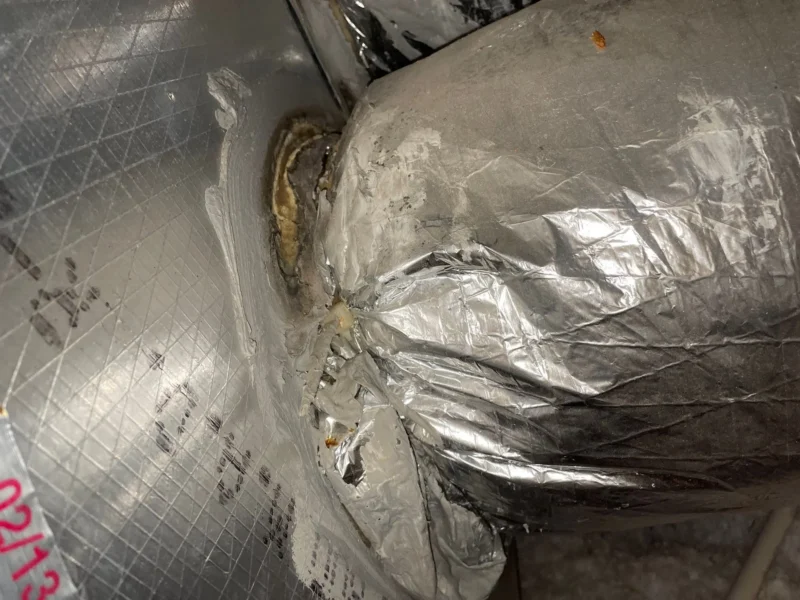 A close up picture of HVAC ductwork separating from a main plenum supply.