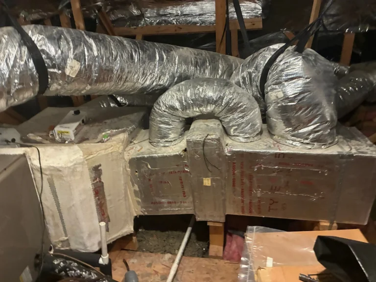 Flexible HVAC ductwork in an attic connected to the main supply plenum of an HVAC system.